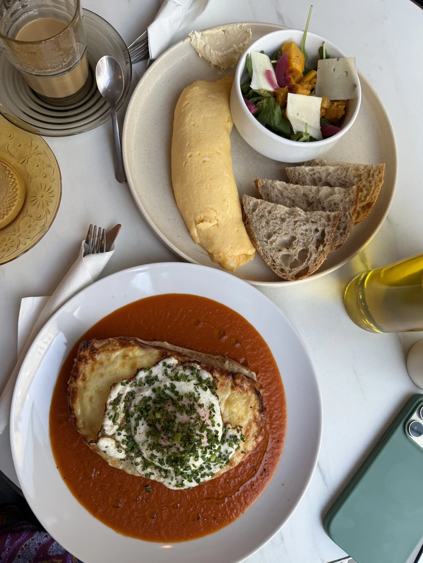Dwa dania śniadaniowe na stole: Croque Madame i omlet francuski.